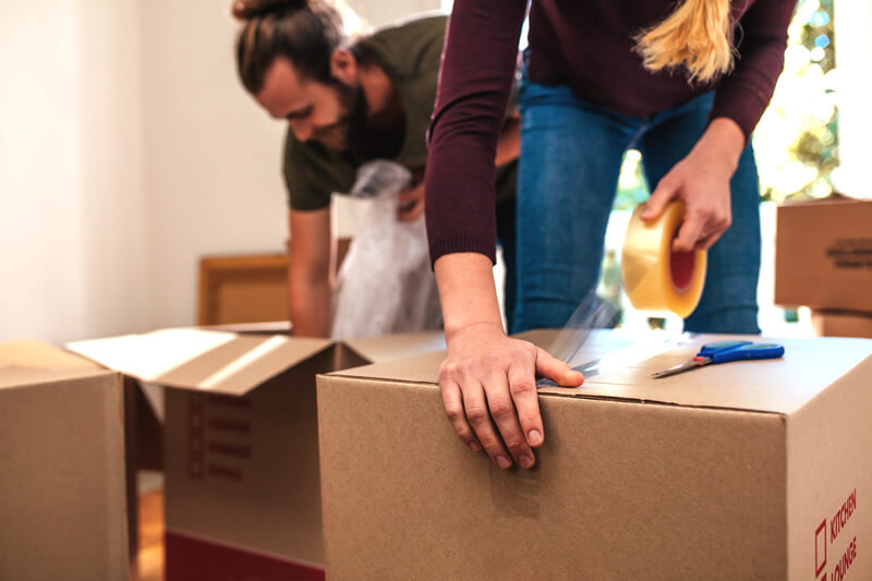 A woman packs moving boxes