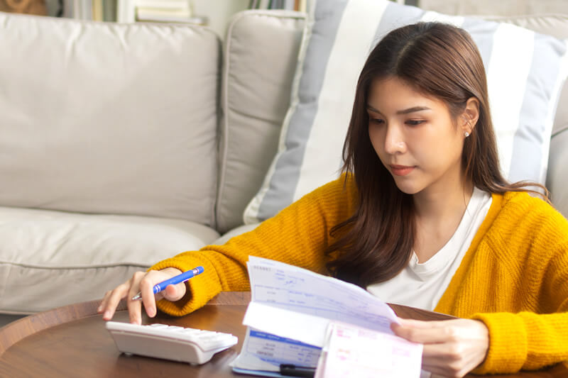 A young woman calculates her savings.